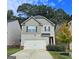 Two-story house with a white garage door and landscaping at 85 Milton Dr, Covington, GA 30016