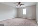 Well-lit bedroom featuring neutral walls, carpet flooring, and a ceiling fan at 2172 Red Rose Ln, Loganville, GA 30052