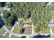 House nestled on a wooded lot with a pool nearby at 115 Worthy Dr, Mcdonough, GA 30252