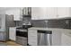 Modern kitchen with stainless steel appliances and dark gray tile backsplash at 3060 Nw Pharr Cts # 317, Atlanta, GA 30305