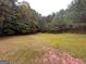 Wooded backyard with a large grassy area at 166 Greentree Trl, Temple, GA 30179