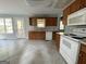 Kitchen with wood cabinets, white appliances, and tile floors. Access to backyard at 166 Greentree Trl, Temple, GA 30179