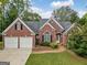 Red brick house with a three-car garage and walkway at 2121 Whitekirk Nw St, Kennesaw, GA 30152