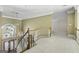 Upstairs hallway with neutral carpeting and elegant chandelier at 115 Eagles Club Dr, Stockbridge, GA 30281