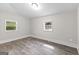 Bright bedroom with wood-look floors and two windows at 26 Pool Woods Dr, Grantville, GA 30220
