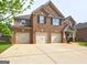 Beautiful brick home with a covered entryway and a three-car garage at 1263 Polk Xing, Mcdonough, GA 30252