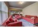 Living room with two red sofas, a patterned rug, and a view into the dining area at 1263 Polk Xing, Mcdonough, GA 30252