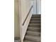 Carpeted staircase with a wooden handrail at 4330 Cedar Valley Ln, Conley, GA 30288