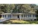 Ranch style home with light beige siding, a covered porch, and landscaping at 3869 Rosedale Ln, Douglasville, GA 30135