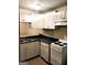 Efficient kitchen with white cabinets, dark countertops, and appliances at 5914 Sutcliff Sq, Lithonia, GA 30058