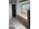 Bathroom featuring a large garden tub and tiled flooring at 938 Mulberry Fields Cv, Auburn, GA 30011