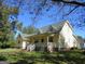 Yellow house with a green roof, front porch, and landscaping at 402 Thurman Rd, Stockbridge, GA 30281