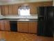 Galley kitchen with wood cabinets and black appliances at 402 Thurman Rd, Stockbridge, GA 30281