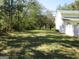 Large grassy backyard with mature trees and side yard at 402 Thurman Rd, Stockbridge, GA 30281