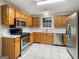 Kitchen with oak cabinets, stainless steel appliances, and tile floor at 205 Creekside Way, Mcdonough, GA 30252