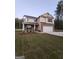 Two-story house with tan siding and a white garage door at 200 Parker Dr, Mcdonough, GA 30253