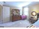 Charming bedroom with dresser, nightstand, and a window with natural light at 5260 Island Dr, Stone Mountain, GA 30087