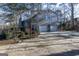 Two-car garage with gray siding and wooded backdrop at 5260 Island Dr, Stone Mountain, GA 30087