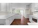 Eat-in kitchen with white cabinets, hardwood floors, and a breakfast bar at 920 Eskew Rd, Mcdonough, GA 30252