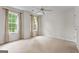 Bright bedroom with two windows, ceiling fan, and neutral carpeting at 920 Eskew Rd, Mcdonough, GA 30252