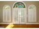 French doors with arched stained-glass window above, flanked by windows with plantation shutters at 5335 Saville Dr, Acworth, GA 30101
