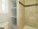 Bathroom with tiled shower/tub combo, built-in shelving, and toilet at 5335 Saville Dr, Acworth, GA 30101