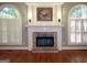 Spacious living room featuring a brick fireplace, hardwood floors, and large windows with plantation shutters at 5335 Saville Dr, Acworth, GA 30101