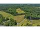Aerial view of a property with a long road, lush green fields, and trees at 655 Mcdonough Rd, Hampton, GA 30228