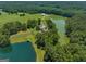 Aerial view of a home on a large lot with two ponds, lush trees, and a barn at 655 Mcdonough Rd, Hampton, GA 30228