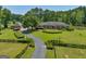 Brick home nestled on a spacious lot with a long driveway, lush landscaping, and pond at 655 Mcdonough Rd, Hampton, GA 30228
