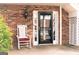Front door entrance with rocking chair and brick facade at 12 Intown Pl, Fayetteville, GA 30214