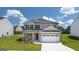 Two-story house with a white two-car garage and brick front at 660 Edgar St # 158, Hampton, GA 30228
