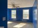 Spacious bedroom with blue walls, two windows, and a ceiling fan at 715 Hennepin Ter, Mcdonough, GA 30253