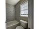Small bathroom with a bathtub, toilet and marble tile at 150 Turman Se Ave, Atlanta, GA 30315