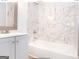 Updated bathroom with gray vanity, marble tile, and bathtub at 3363 Delmar Nw Ln, Atlanta, GA 30331