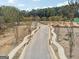 Another view of the community entrance road, with sidewalks and landscaping at 4333 Shiloh Rd, Cumming, GA 30040