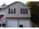 Tan two-story house with red accents and attached garage at 6995 Pine Shadow Way, Winston, GA 30187