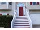 Front entry with red door and white steps leading to house at 6995 Pine Shadow Way, Winston, GA 30187