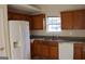 Kitchen with ample wood cabinets, granite countertops, and a white refrigerator at 6995 Pine Shadow Way, Winston, GA 30187