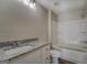 Bathroom with granite countertop, white cabinets and a shower/tub combo at 5122 Hillcrest Nw Dr, Covington, GA 30014