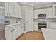 Modern kitchen with white cabinets, stainless steel appliances, and gray backsplash at 684 Brooks Woolsey Rd, Brooks, GA 30205