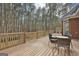 Spacious deck with wooded backdrop, seating area, and grill at 684 Brooks Woolsey Rd, Brooks, GA 30205