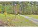 Long gravel driveway lined with trees and flowering bushes at 684 Brooks Woolsey Rd, Brooks, GA 30205