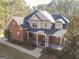 Two-story brick house with a large front porch and attached garage at 684 Brooks Woolsey Rd, Brooks, GA 30205