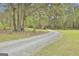 Gravel driveway leading to a charming house nestled among trees at 684 Brooks Woolsey Rd, Brooks, GA 30205