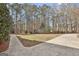 Large, grassy backyard with a paved walkway and driveway at 684 Brooks Woolsey Rd, Brooks, GA 30205
