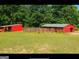 Two red barns with green roofs and fenced pastures at 7866 Hwy 54, Sharpsburg, GA 30277