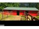 Red barn with green roof and wooden fence at 7866 Hwy 54, Sharpsburg, GA 30277