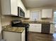 Modern kitchen with white cabinets, granite countertops and stainless steel appliances at 1370 David Cir, Decatur, GA 30032
