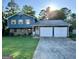 Two-story blue house with double garage and well-maintained lawn at 6091 Katherine Rd, Rex, GA 30273